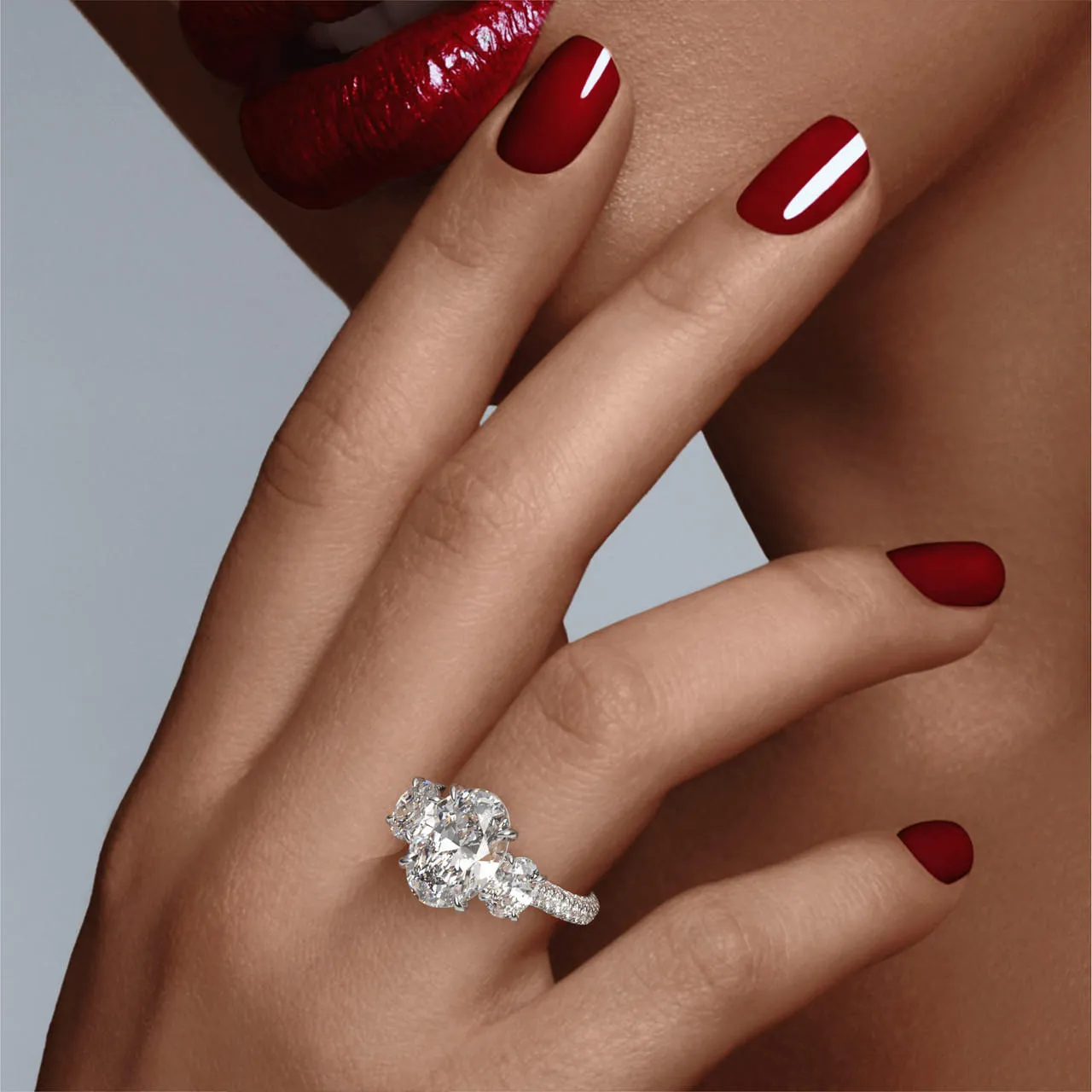 OVAL CUT DIAMOND ENGAGEMENT RING WITH A THREE STONE THREE PHASES TRIPLE PAVE SETTING IN PLATINUM