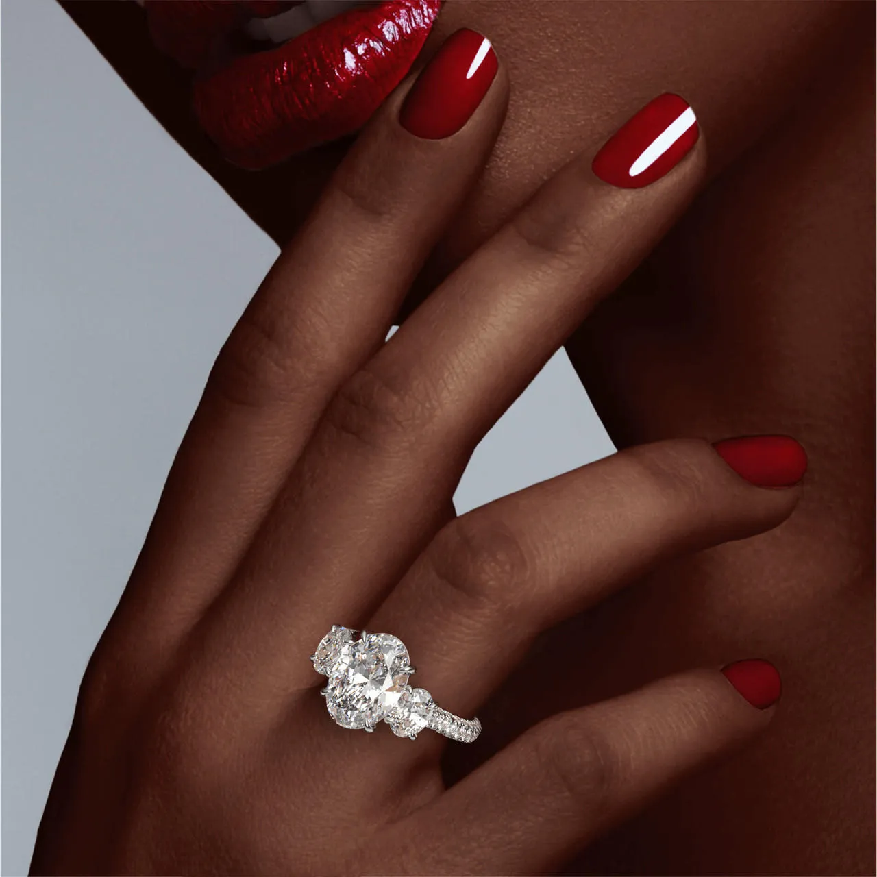 OVAL CUT DIAMOND ENGAGEMENT RING WITH A THREE STONE THREE PHASES TRIPLE PAVE SETTING IN PLATINUM